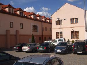 a parking lot with cars parked in front of a building at Parkhotel Centrum in Spišská Nová Ves