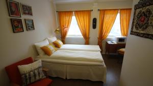 een slaapkamer met een bed, een stoel en ramen bij Hotell Magnor Bad in Magnor