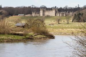 a view of a castle and a river with a building at The Old Seed Store in Kelso