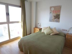 a bedroom with a bed and a large window at Apt. Alegria in Conil de la Frontera
