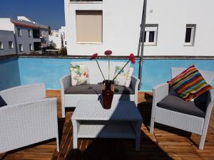 a vase on a table on a balcony with chairs at Apt. Alegria in Conil de la Frontera