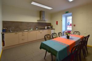 a kitchen with a table and some chairs and a kitchen with a table at Saare Automatic Hostel in Pärnu