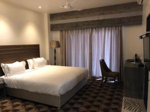 een hotelkamer met een groot bed en een raam bij Hotel Sharanam in Shegaon