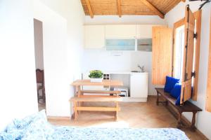 a living room with a table and a kitchen at Quinta Teresinha in Estômbar