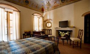 a bedroom with a bed and a tv and a fireplace at Hotel Corallo in Pomonte