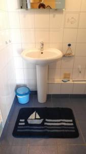 een badkamer met een wastafel en een zwart-wit tapijt bij La Caravelle 10 Boulevard Gilbert Longuet in Arromanches-les-Bains