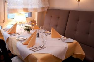 una mesa con un mantel blanco y servilletas. en Hotel Rosenflora en Nideggen
