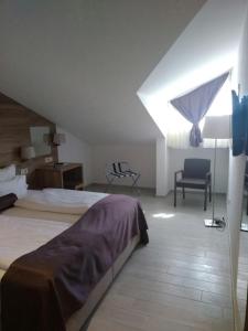a bedroom with a bed and a chair and a window at Hotel Biokovo in Makarska