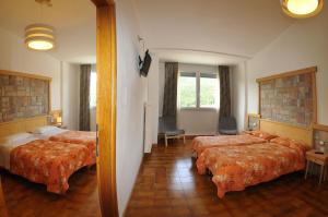 Postel nebo postele na pokoji v ubytování Hotel Piancastello
