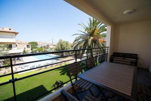 un balcone con tavolo, sedie e piscina di Residence Saletta Casale a LʼÎle-Rousse