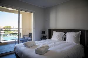 una camera da letto con un grande letto con asciugamani di Residence Saletta Casale a LʼÎle-Rousse