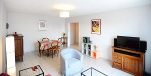 里昂的住宿－Appart' Dauphiné，客厅配有电视、椅子和桌子