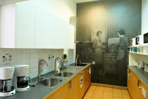 a kitchen with a painting of a man and a woman at Warsaw Hostel Centrum Private Rooms & Dorms in Warsaw