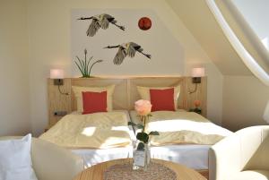 ein Schlafzimmer mit einem Bett und einer Vase aus Blumen auf einem Tisch in der Unterkunft Alago Hotel am See in Cambs