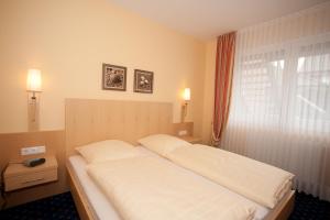 Säng eller sängar i ett rum på Akzent Hotel Hubertus