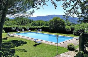 Una piscina en un patio con dos sillas. en Villa Enrica, en Santa Maria a Vezzano