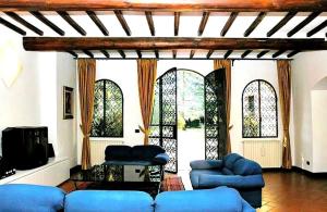 a living room with blue couches and stained glass windows at Villa Enrica in Santa Maria a Vezzano