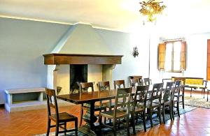 Un comedor con mesa y sillas y chimenea. en Villa Enrica, en Santa Maria a Vezzano