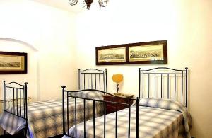 2 camas de metal en una habitación con ventana en Villa Enrica, en Santa Maria a Vezzano 7 fotos más