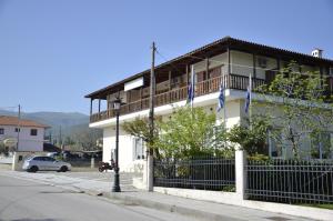 a white building with a balcony on a street at Pension Vergina in Vergina