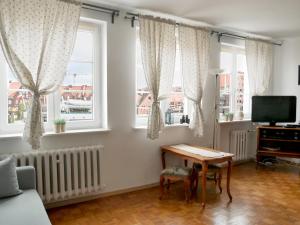 - un salon avec une table et 2 fenêtres dans l'établissement Motlawa River Apartment, à Gdańsk