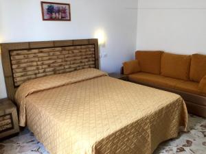 1 dormitorio con 1 cama y 1 sofá en B&B San Vito, en San Vito lo Capo