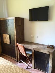 a desk with a chair and a television on a wall at B&B San Vito in San Vito lo Capo