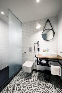 a bathroom with a sink and a toilet at Pentahotel Leipzig in Leipzig