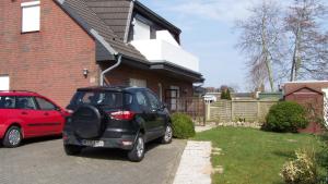 um pequeno carro estacionado em frente a uma casa em Goden Wind 20 em Westerdeichstrich