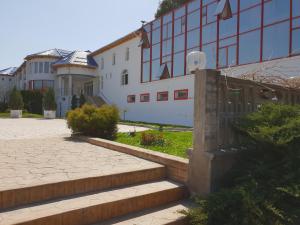 Motru的住宿－Pensiunea Ghiocela，前面有楼梯的白色建筑