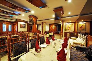 a restaurant with a table with red napkins on it at Hotel Zeeras in Varanasi