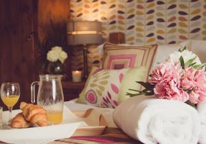 Windy Harbour restaurant and accommodation في جلوسوب: سرير مع طاولة مع صحن من الخبز وكأس من النبيذ
