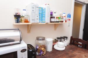 a kitchen counter with food items on top of a microwave at Budget Hostel in Newcastle upon Tyne