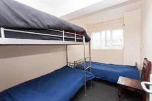 2 literas con sábanas azules en una habitación en Budget Hostel, en Newcastle