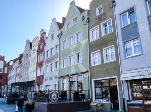 a row of buildings on a city street at Motlawa River Apartment in Gdańsk