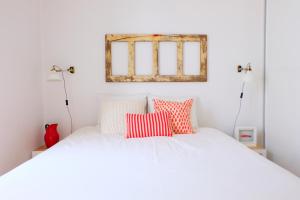 リスボンにあるLuz do Rioのベッドルーム1室(赤と白の枕が備わるベッド1台付)