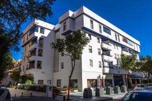 un bâtiment blanc avec un arbre devant lui dans l'établissement Apartment in Marbella Milla de Oro, à Marbella