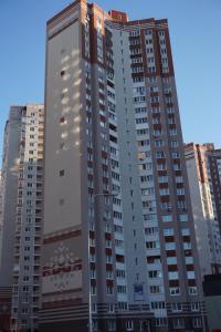un edificio alto en una ciudad con edificios altos en Cosy Apartment at Pozniaky, en Kiev