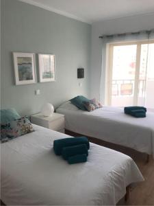 sypialnia z 2 łóżkami i oknem w obiekcie Apartamento T&T Ocean no Clube Praia da Rocha. w mieście Portimão