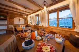 una sala da pranzo con tavolo e cibo di Im Kranzhof a San Candido