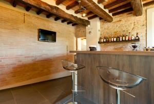 eine Bar mit zwei Stühlen neben einer Ziegelwand in der Unterkunft Locanda Sant'Ambrogio in Rivalta
