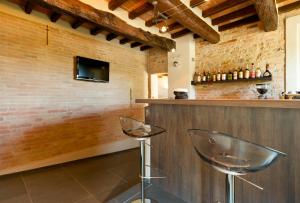 bar z dwoma krzesłami obok ściany z cegły w obiekcie Locanda Sant'Ambrogio w mieście Rivalta