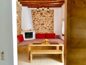 a living room with a table and a fireplace at Bekos traditional house in Archangelos