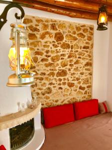 a living room with a stone wall and a couch at Bekos traditional house in Archangelos