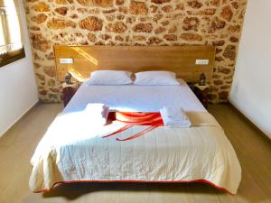 a bedroom with a large bed with two towels on it at Bekos traditional house in Archangelos
