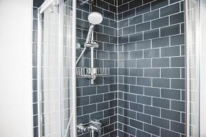 a blue tiled shower with a shower head at The Hostello in Verona