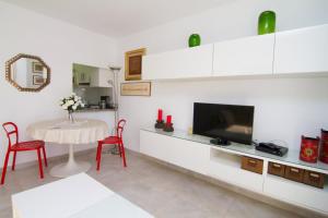 Biały salon ze stołem i telewizorem w obiekcie ALBAIDA II 6i MENYBER w mieście Nerja