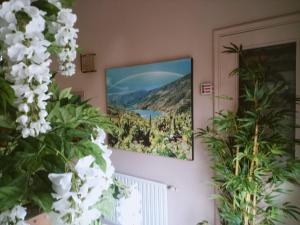 
a vase of flowers on a wall with a picture on the wall at Hotel Arume in Bóveda
