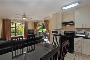 - une cuisine avec une table et des chaises dans la chambre dans l'établissement Uvongo River Resort, à Margate