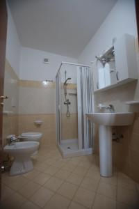 a bathroom with two toilets and a shower and a sink at Hotel Maremonti in Ioppolo